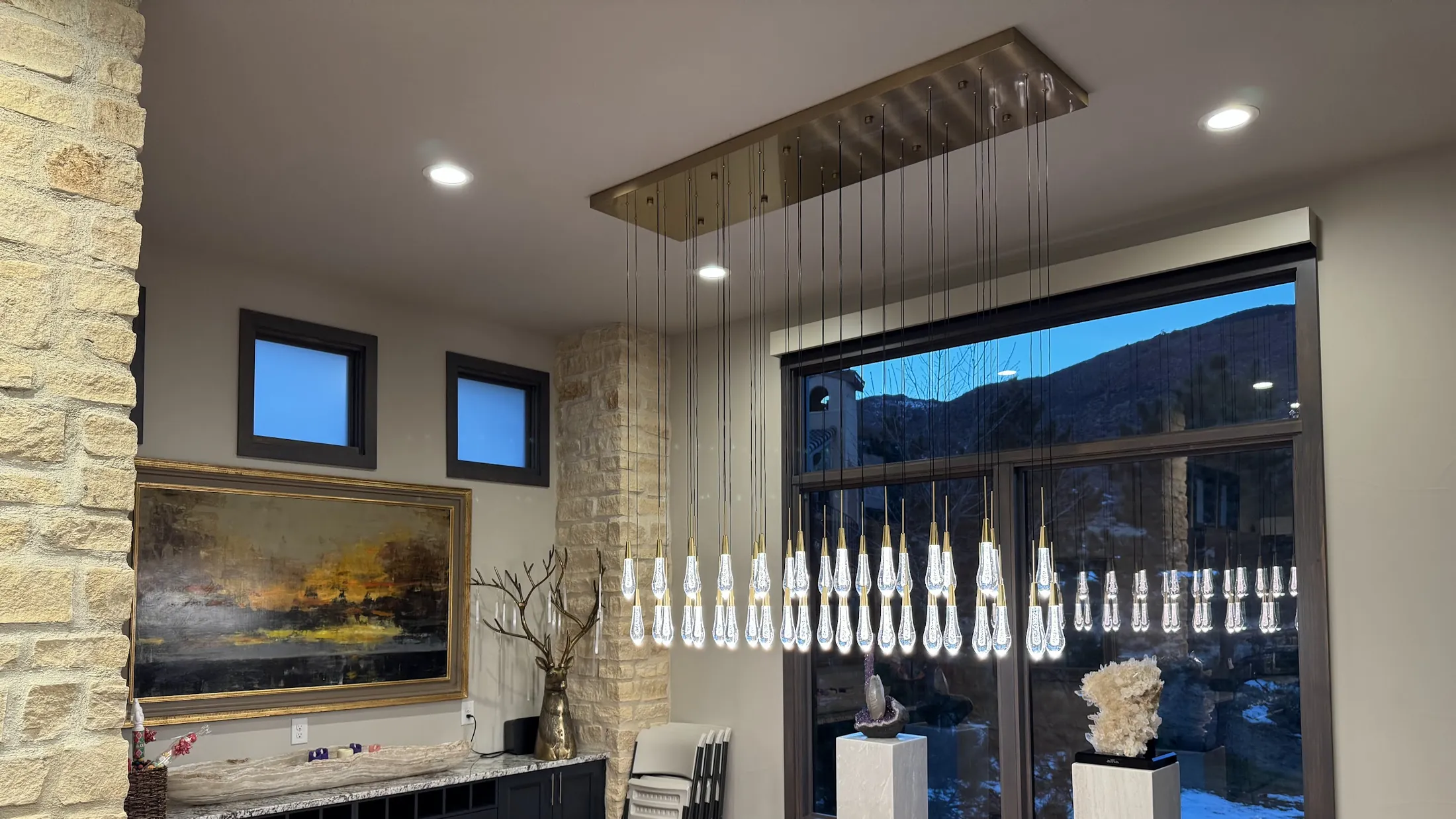 Crystal pendant lit at dusk in front of a window onto the foothills