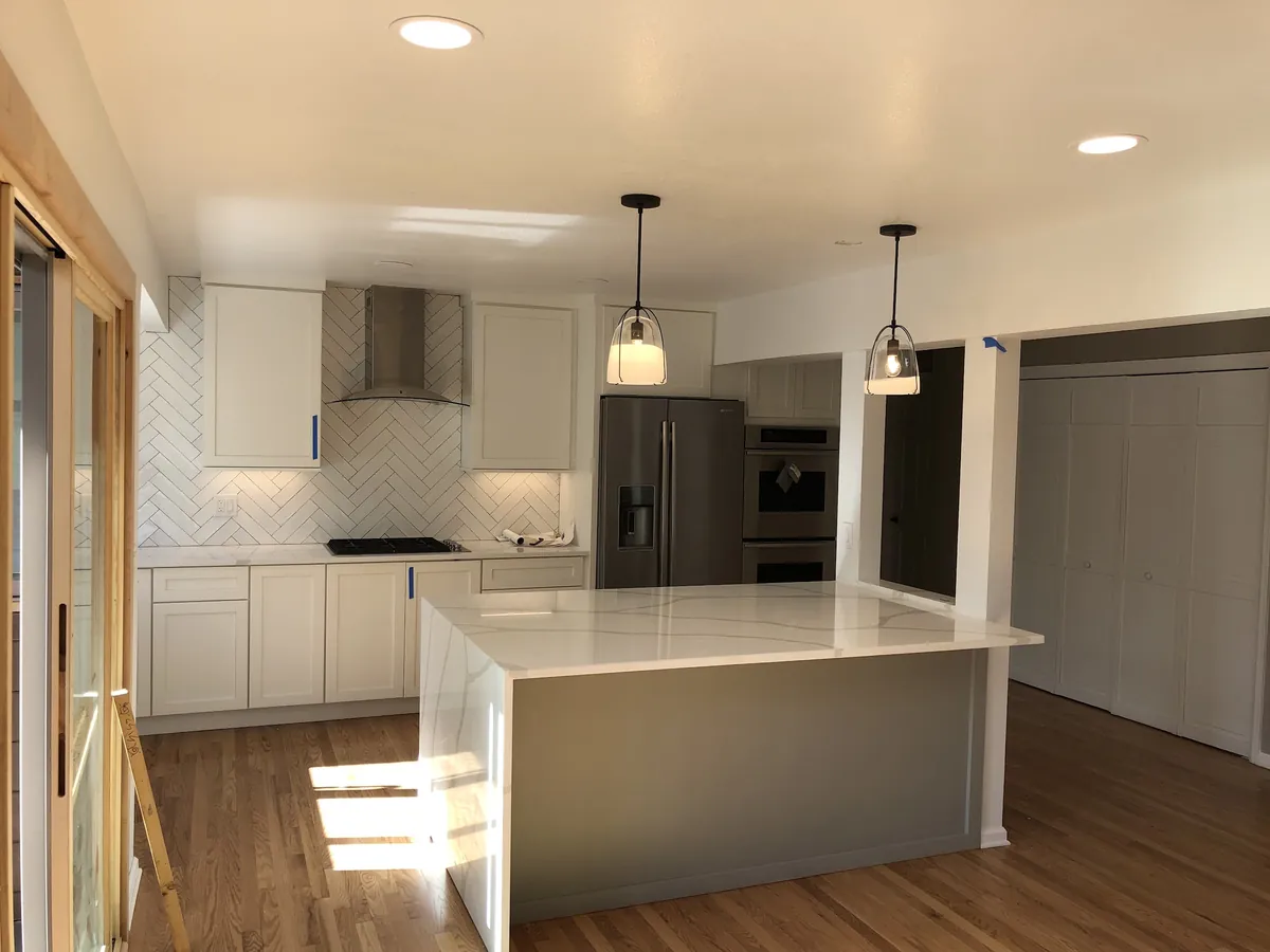 White kitchen with two pendants over a quartz island