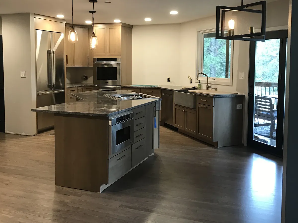 Kitchen with a large island under modern pendants and recessed lights