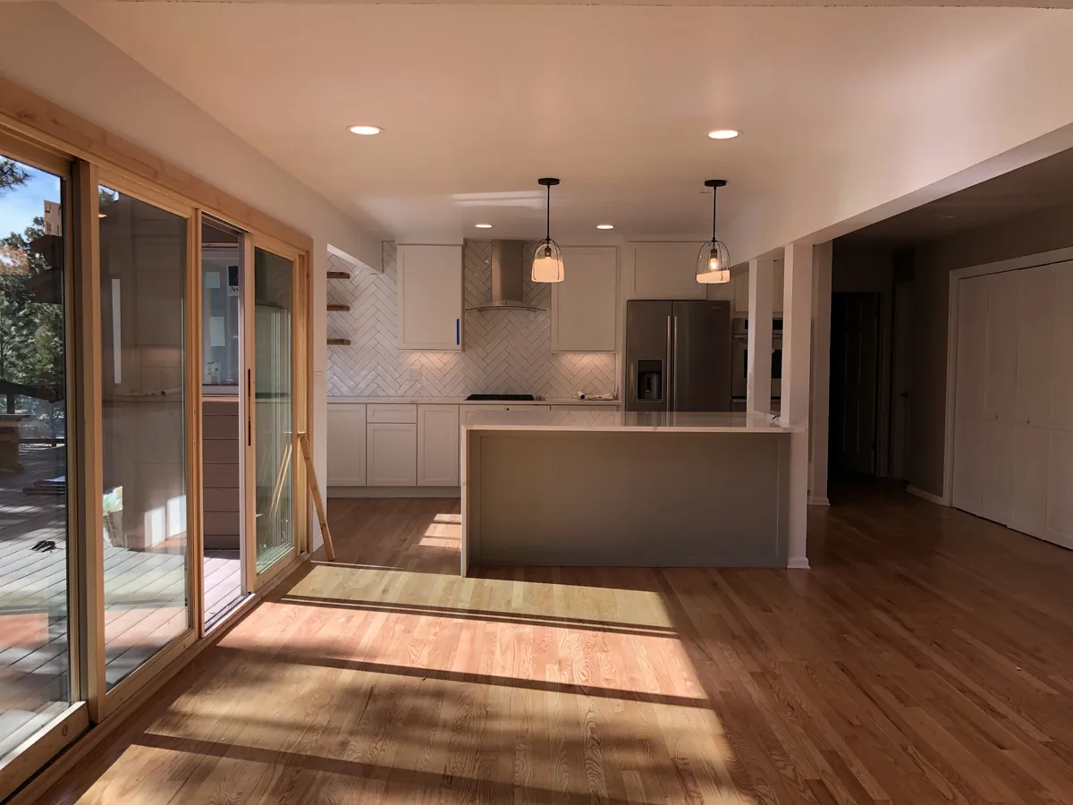 Bright new kitchen with recessed lights, island pendants and wide plank floors